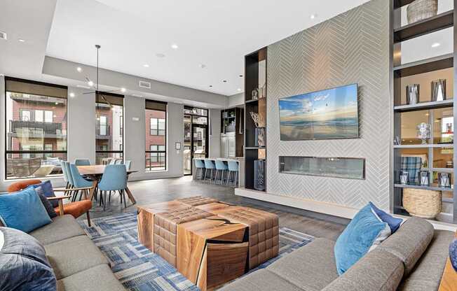 A modern living room with a grey sofa, a wooden coffee table, and a large painting on the wall.