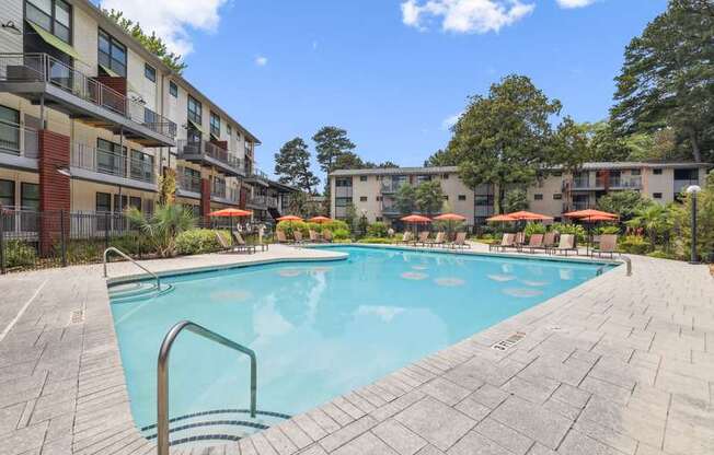 A swimming pool surrounded by apartment buildings and trees.