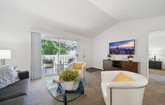 a living room with a couch and a glass coffee table and a tv