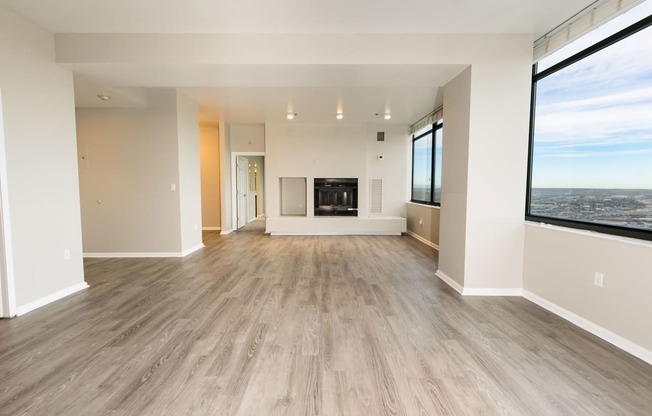 a living room with a fireplace and a large window at Apartments at Denver Place, Denver Colorado