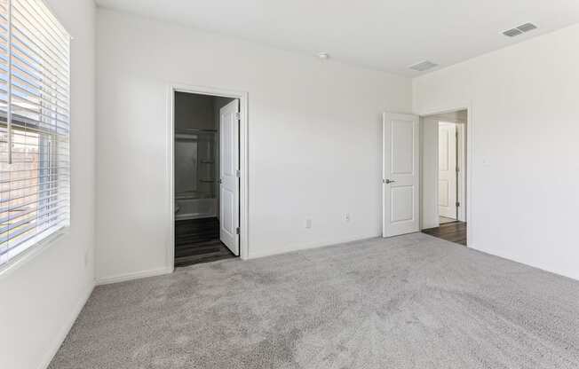 Cozy bedroom with plush carpeting of Dogwood floor plan at Beacon at Presidential Heights in Manor, TX