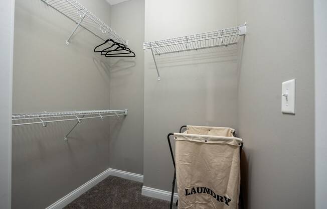 a walk in closet with a bag on the floor and two shelves on the wall