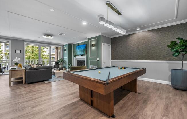Resident Game Lounge with a billiards table, fireplace seating, and open-concept gathering spaces designed for friendly competition and social connection.