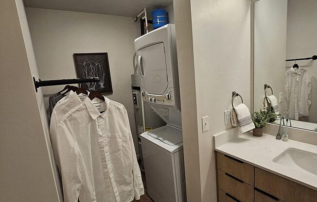 A white shirt hanging on a rack in a bathroom.