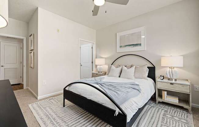 A bedroom with a large bed and a ceiling fan.