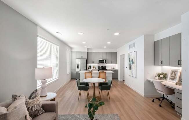 A modern living room with a dining area and kitchen in the background.