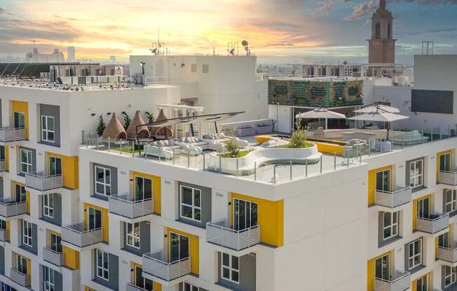 a rendering of a building with a green roof and a sunset in the background