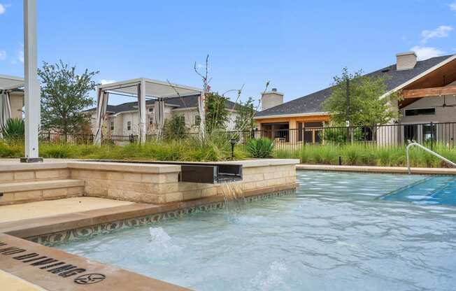 a large swimming pool with a house in the background