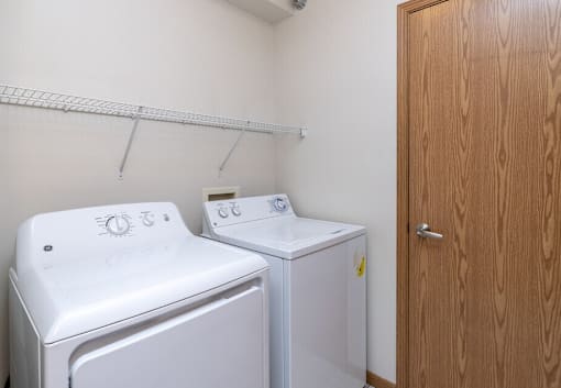 A small laundry room with a washer and dryer.