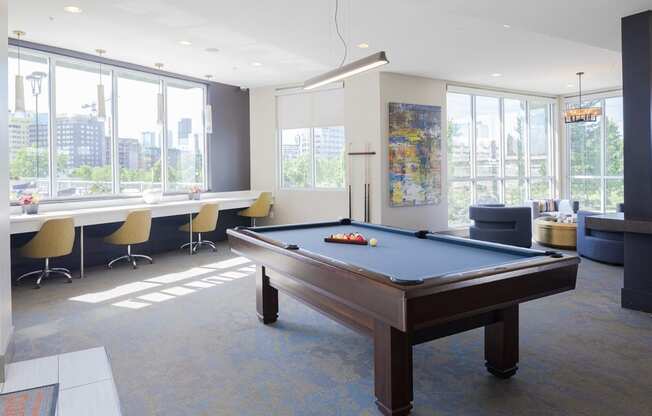 a pool table in a room with large windows
