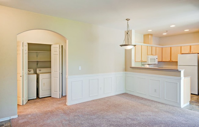 A kitchen with white cabinets and a refrigerator with the door open.