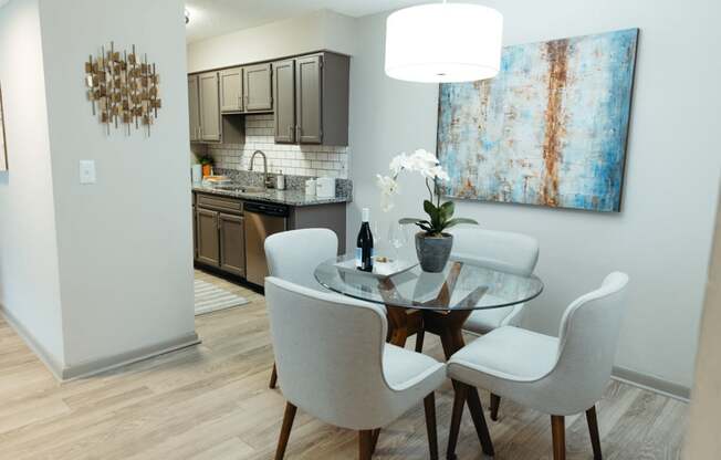 a dining room with a table and chairs and a kitchen