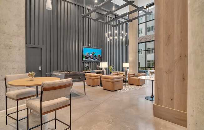 a lobby with chairs and tables and a tv