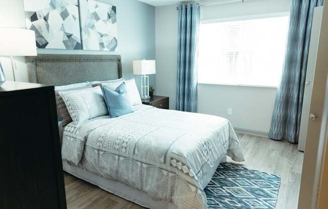 a bedroom with a bed and a dresser and a window