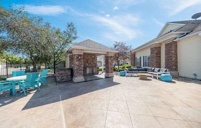 A sunny day at a patio with a table and chairs.