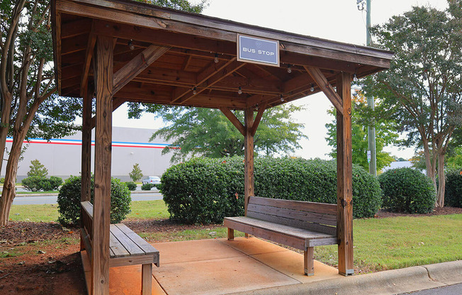 a wooden bench sitting under a wooden pavilion