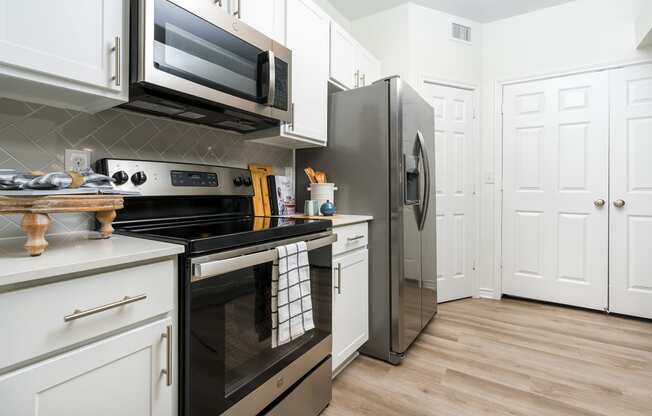 a kitchen with white cabinets and stainless steel appliances