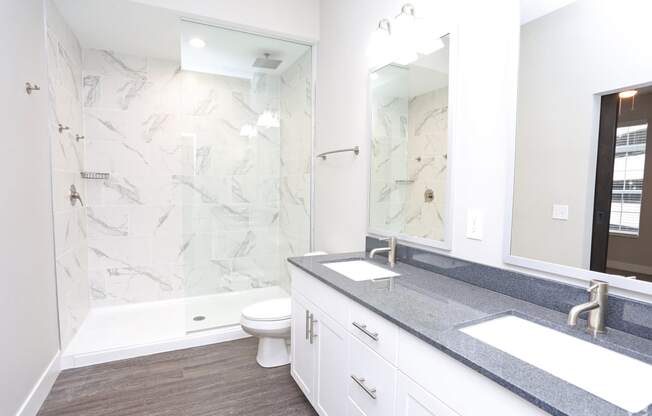 a bathroom with a shower and a sink and a mirror at Century Baxter Avenue, Louisville, KY 40204