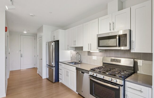 Kitchen with stove top oven and refrigerator at Park77 Apartments, Cambridge