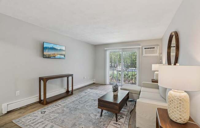 A living room with a couch, a coffee table, and a painting on the wall.