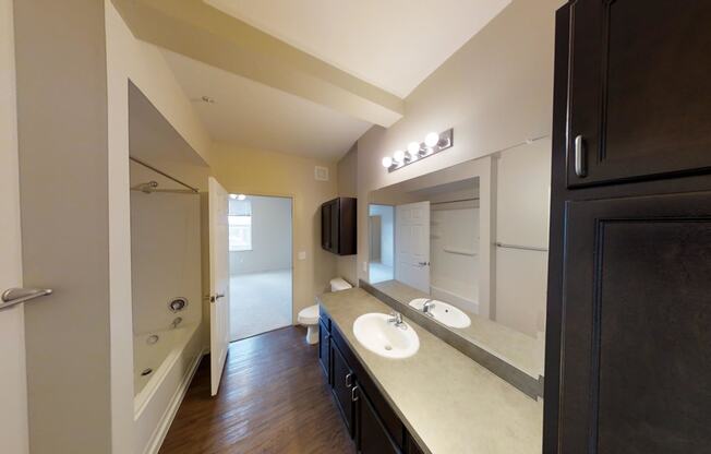 a bathroom with two sinks and a tub and a shower