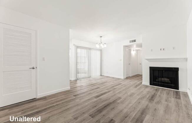 A room with a fireplace and wood flooring.