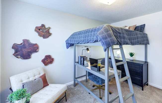 A room with a bunk bed and a white chair.