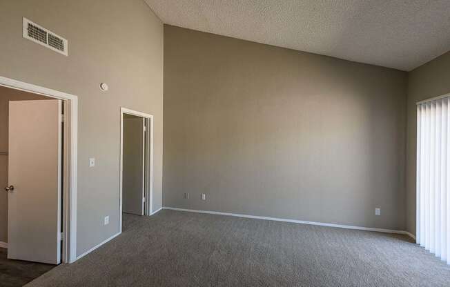 an empty living room with a door to a closet