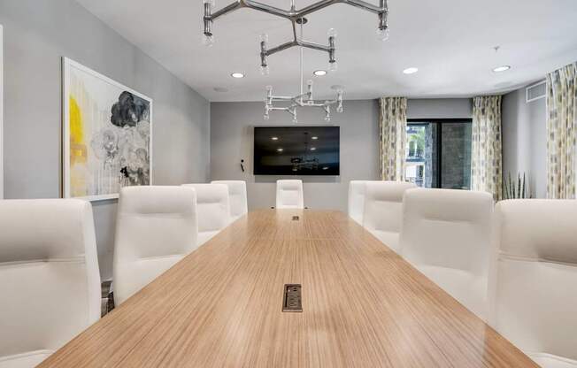 A conference room with a long table and chairs.