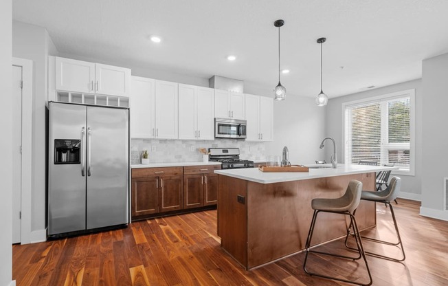 a kitchen with white cabinets and a stainless steel refrigerator