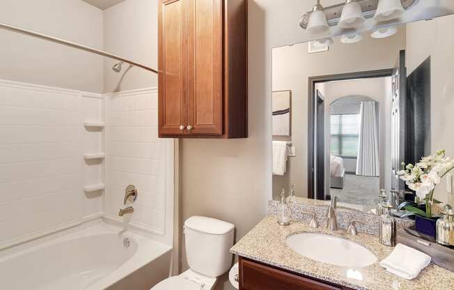 a bathroom with a sink toilet and shower and a mirror