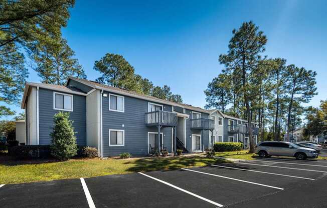 A row of townhouses with a car parked in front.
