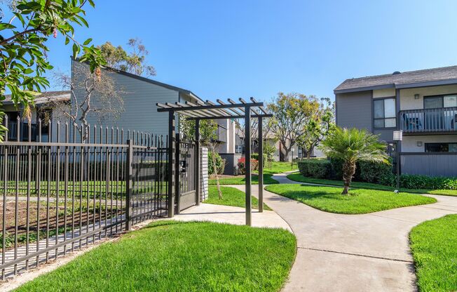 A black gate leads to a walkway in front of a building.