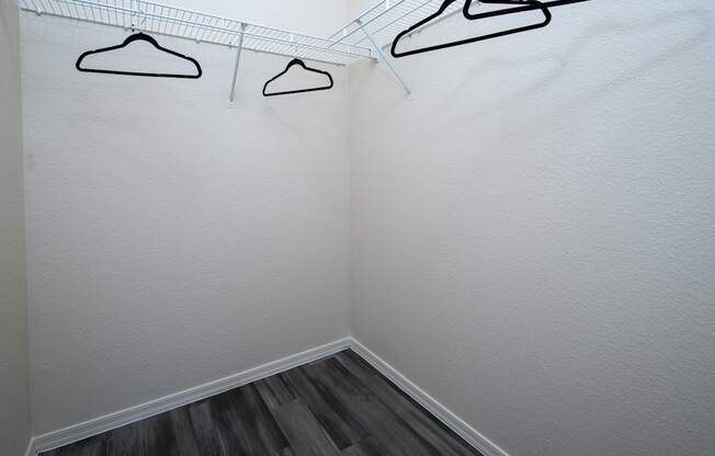 Three hangers are hanging on a wire on a white wall.