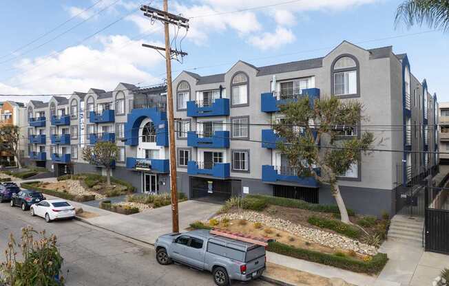 A row of modern townhouses with blue trim and balconies.