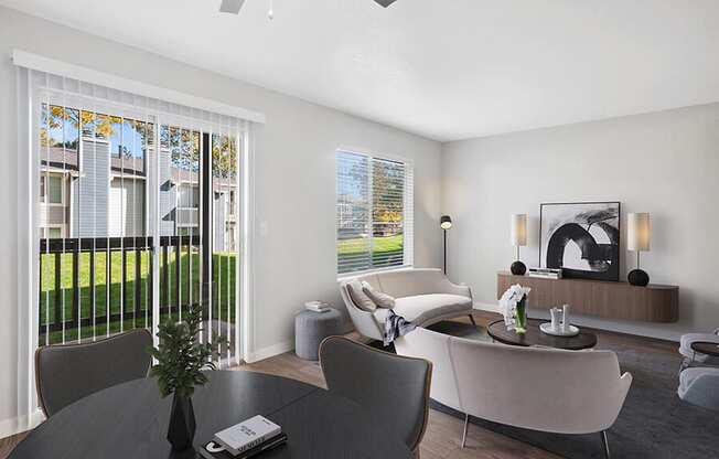 Model Dining/Living Room with Wood-Style Flooring and Patio Accessibility at Overlook Point Apartments in Salt Lake City, UT.