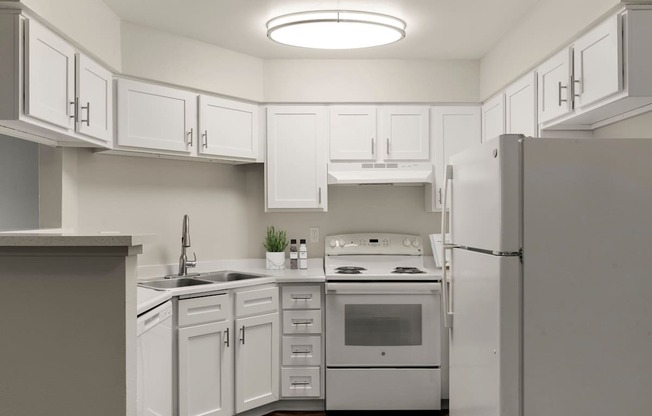 A kitchen with white cabinets and appliances.