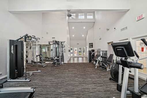 A gym with a variety of equipment including treadmills, weights, and exercise machines.