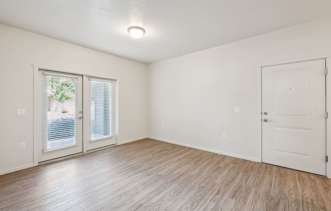 the living room of an empty apartment with a door to the patio