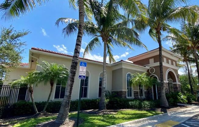 A building with a blue sign on a pole in front of it.