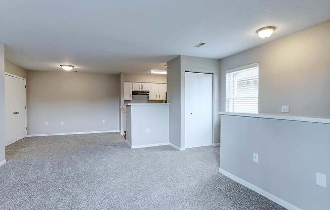 A spacious room with a kitchenette and a window.