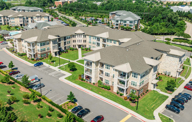 A large apartment complex with a parking lot in front.