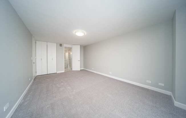 an empty living room with white walls and carpet