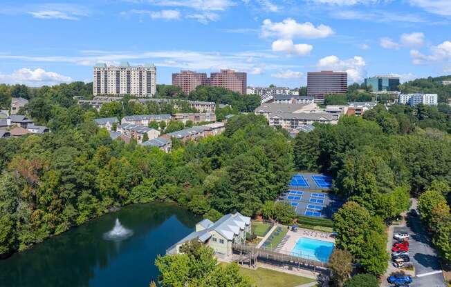 an aerial view of a city with a lake and trees