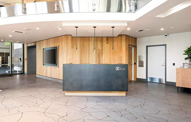 A reception area with a black counter and wooden walls.