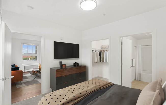 a bedroom with a bed and a tv on the wall