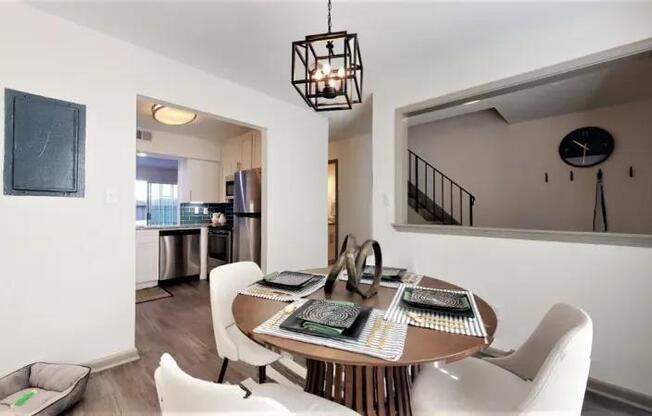 A dining room with a table set for four.