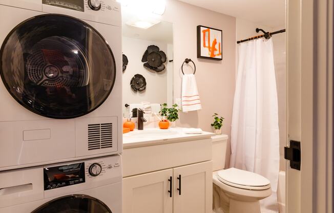 a bathroom with a toilet and a washer and dryer in it