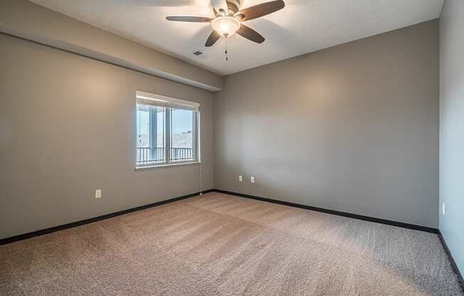 Interiors- Bedroom with ceiling fan and abundant natural lighting at the Villas of Omaha at Butler Ridge in Omaha Nebraska