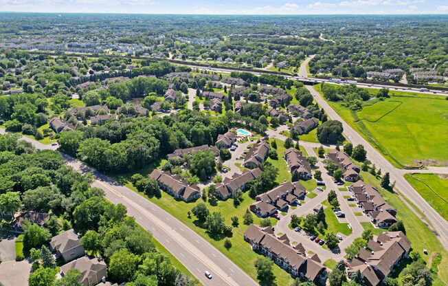 an aerial view of a neighborhood with houses and trees and a highway